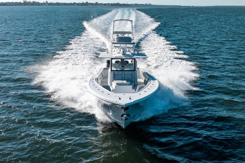  Yacht Photos Pics 2023 Yellowfin 42 Offshore boat cruising on open water, creating a dynamic wake.