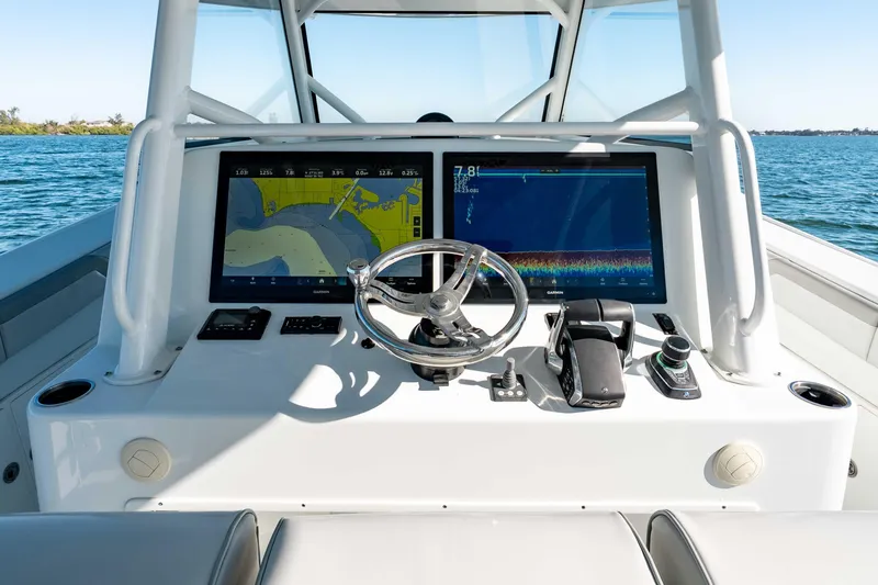  Yacht Photos Pics 2023 Yellowfin 42 Offshore boat dashboard with navigation screens and steering wheel.