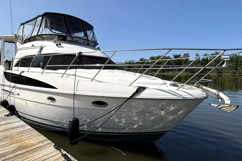  Yacht Photos Pics 2004 Meridian 459 Cockpit Motoryacht docked on calm water under clear blue sky.