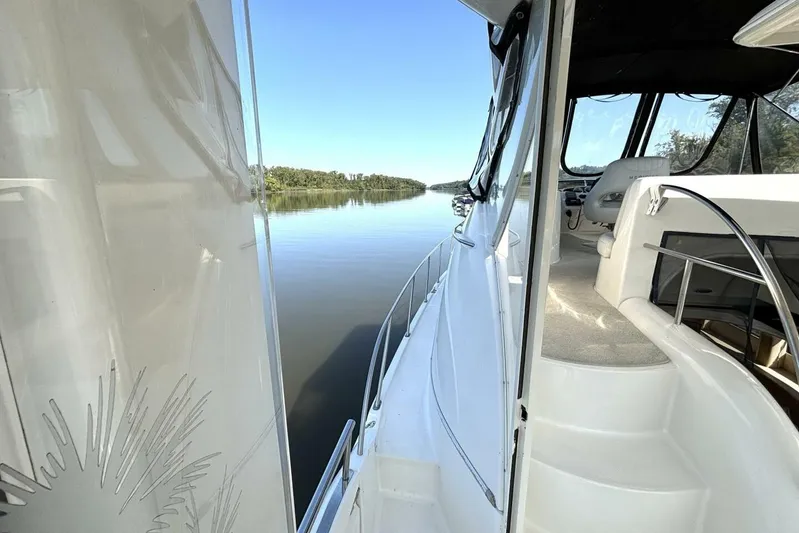  Yacht Photos Pics 2004 Meridian 459 Cockpit Motoryacht on serene waterway, showcasing sleek design and spacious deck.