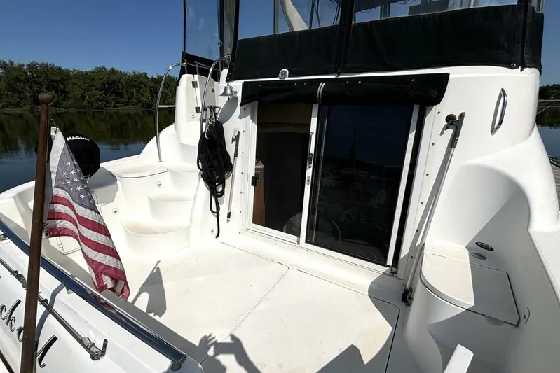  Yacht Photos Pics 2004 Meridian 459 Cockpit Motoryacht with American flag, docked on a serene lake.