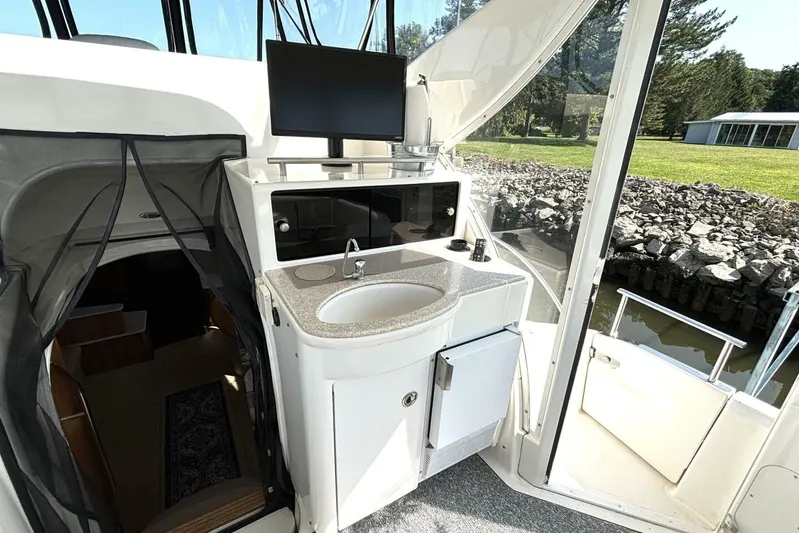  Yacht Photos Pics 2004 Meridian 459 Cockpit Motoryacht interior with sink, TV, and outdoor view.