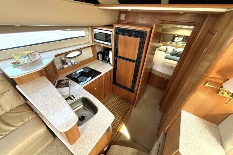  Yacht Photos Pics 2004 Meridian 459 Cockpit Motoryacht interior with kitchen, sink, stove, and cozy bedroom.