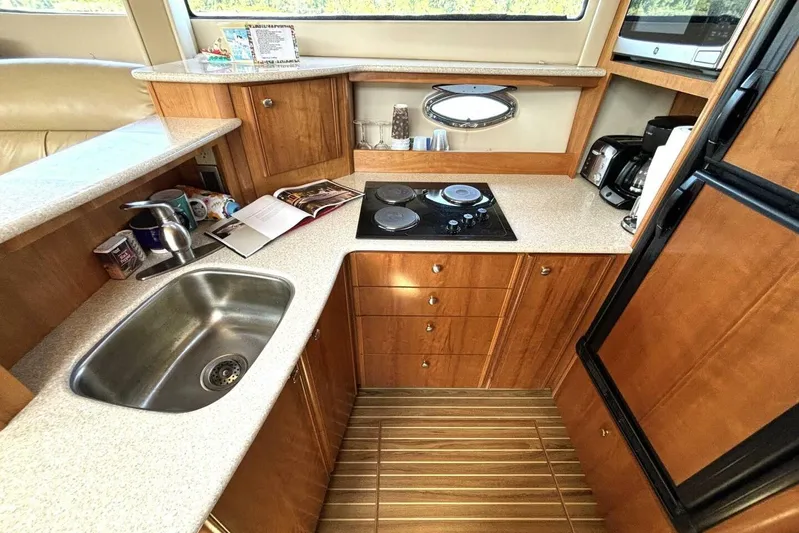  Yacht Photos Pics Luxurious 2004 Meridian 459 Cockpit Motoryacht kitchen with modern amenities and wood cabinetry.
