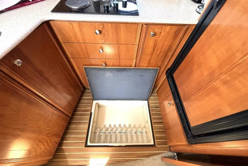  Yacht Photos Pics 2004 Meridian 459 Cockpit Motoryacht kitchen with wooden cabinets and open fridge.