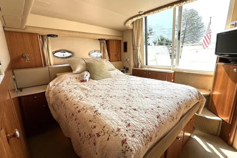  Yacht Photos Pics Luxurious bedroom interior of 2004 Meridian 459 Cockpit Motoryacht with cozy bedding and natural light.