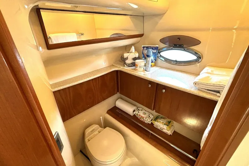  Yacht Photos Pics 2004 Meridian 459 Cockpit Motoryacht bathroom with wooden cabinetry and porthole window.