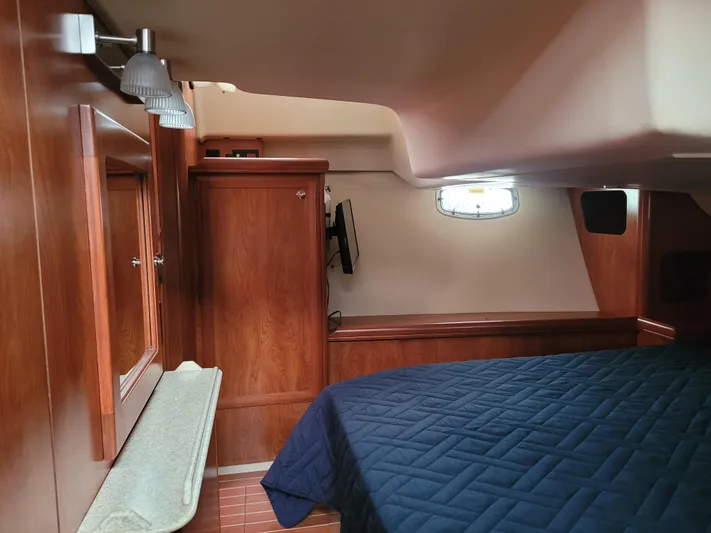 Caribbean Breeze Yacht Photos Pics Interior of 2010 Hunter 45 Deck Salon with wood paneling and blue bedding.