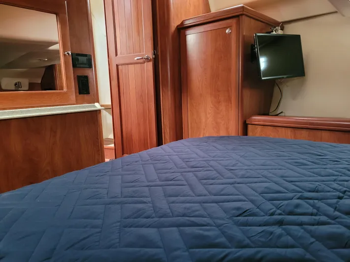 Caribbean Breeze Yacht Photos Pics Interior of 2010 Hunter 45 Deck Salon with wood cabinetry and blue quilted bedding.