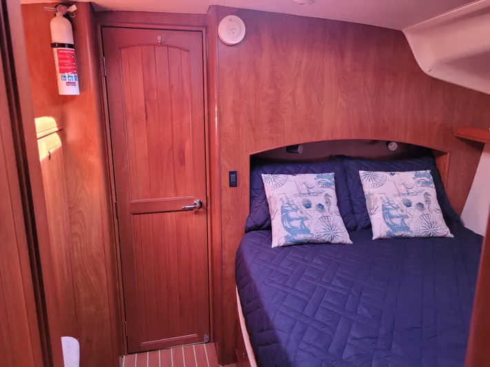 Caribbean Breeze Yacht Photos Pics Cozy cabin interior of 2010 Hunter 45 Deck Salon with wooden finish and nautical-themed bedding.