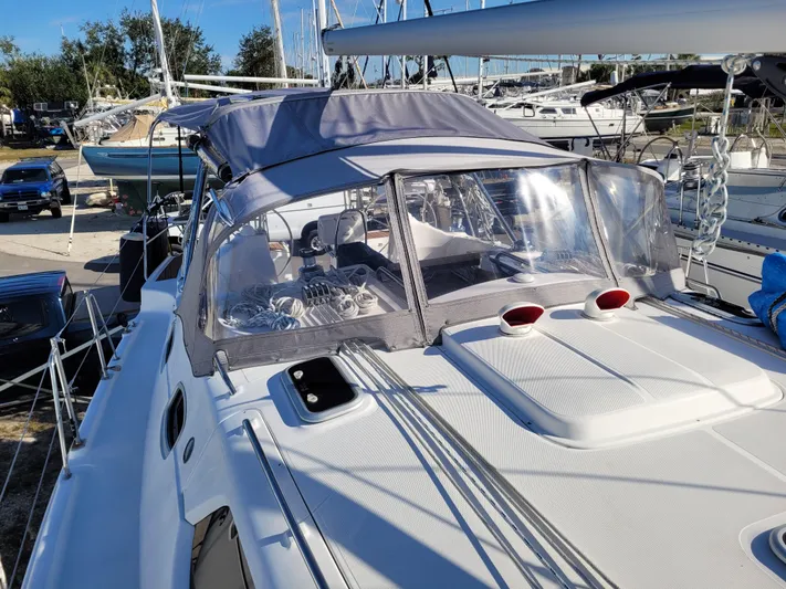 Caribbean Breeze Yacht Photos Pics 2010 Hunter 45 Deck Salon sailboat with covered cockpit, docked in a marina.