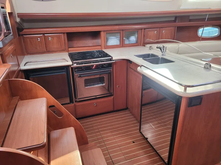 Caribbean Breeze Yacht Photos Pics Interior of 2010 Hunter 45 Deck Salon yacht kitchen with wood cabinetry and modern appliances.