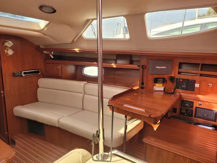 Caribbean Breeze Yacht Photos Pics Interior of 2010 Hunter 45 Deck Salon with wood finish and beige seating.
