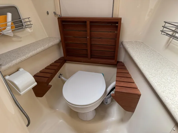 Caribbean Breeze Yacht Photos Pics Toilet area in 2010 Hunter 45 Deck Salon yacht with wooden accents and storage shelves.