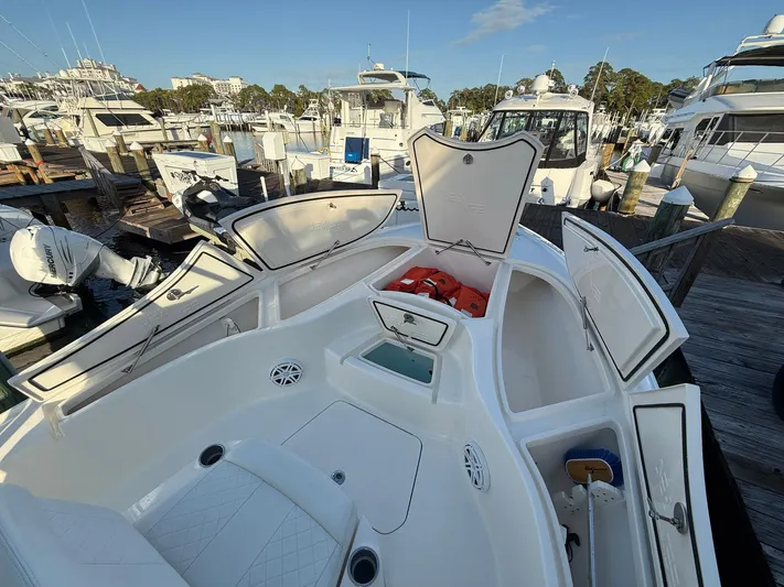  Yacht Photos Pics 2018 SeaVee 270Z boat with open storage compartments at a marina.