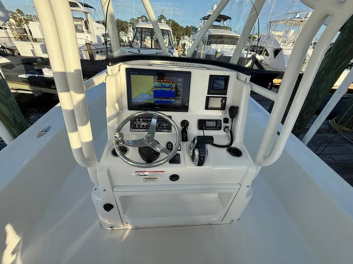  Yacht Photos Pics 2018 SeaVee 270Z boat console with navigation equipment and steering wheel at marina.