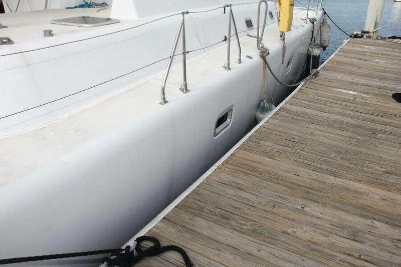 Chasing The Dream Yacht Photos Pics Side view of a 1995 Voyage Yachts Mayotte docked at a wooden pier.