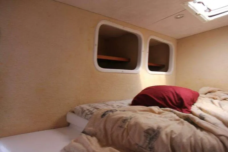Chasing The Dream Yacht Photos Pics Cozy cabin interior of 1995 Voyage Yachts Mayotte with bed and portholes.