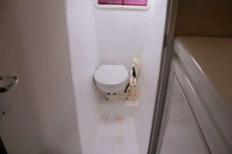 Chasing The Dream Yacht Photos Pics Compact bathroom on 1995 Voyage Yachts Mayotte, featuring a marine toilet and white interior.