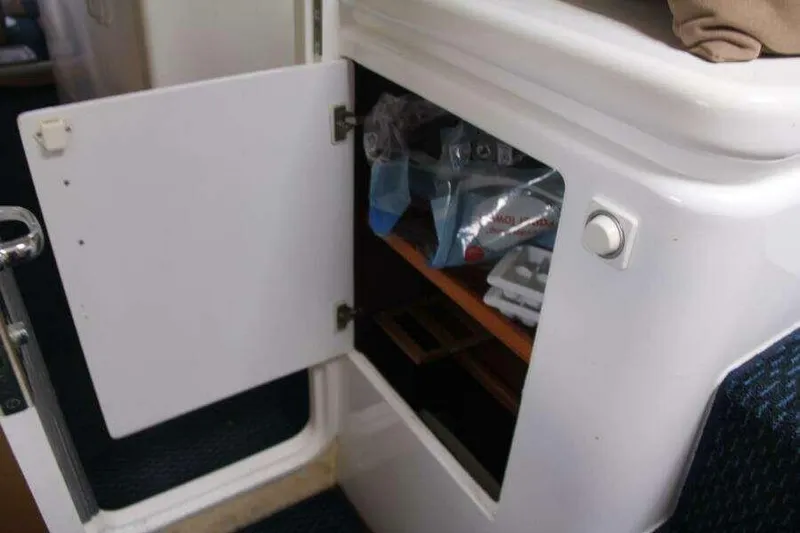 Chasing The Dream Yacht Photos Pics Open storage compartment on 1995 Voyage Yachts Mayotte, showing interior shelves and contents.