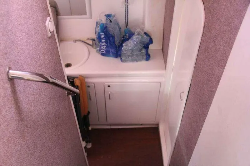 Chasing The Dream Yacht Photos Pics Compact bathroom in 1995 Voyage Yachts Mayotte with sink and storage cabinets.