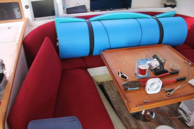 Chasing The Dream Yacht Photos Pics Interior of 1995 Voyage Yachts Mayotte with red seating and a wooden table.
