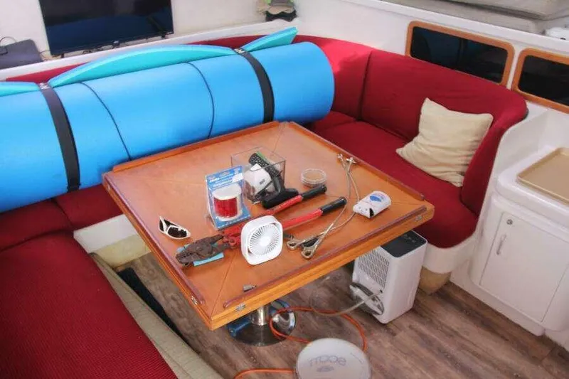 Chasing The Dream Yacht Photos Pics Interior of 1995 Voyage Yachts Mayotte with red seating, table, and various tools.