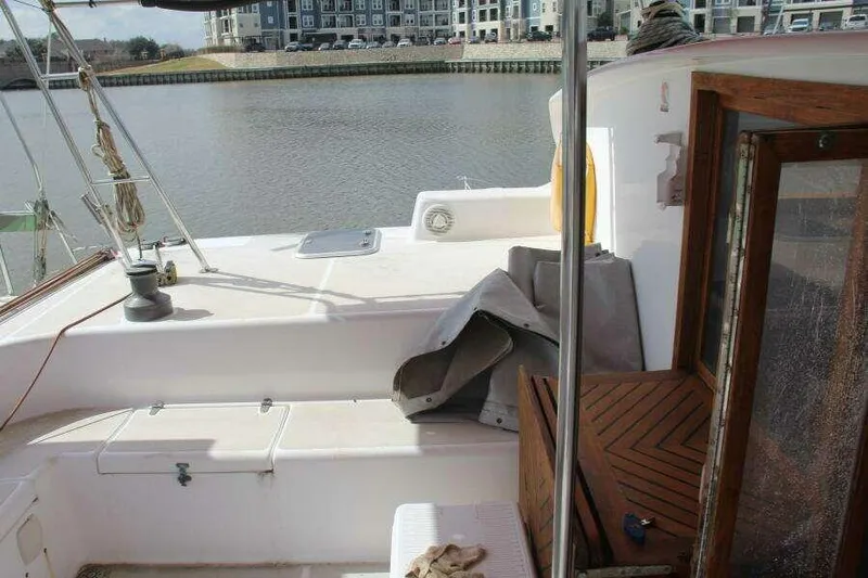 Chasing The Dream Yacht Photos Pics 1995 Voyage Yachts Mayotte catamaran deck with wooden accents, docked by waterfront buildings.