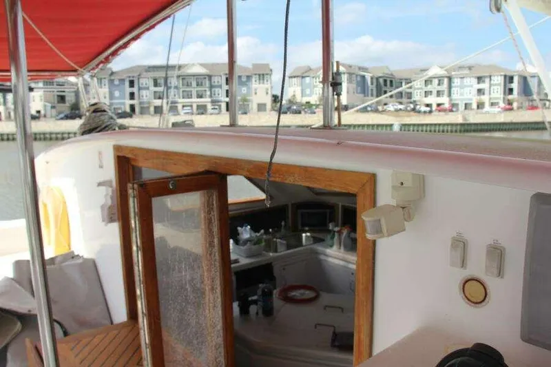 Chasing The Dream Yacht Photos Pics 1995 Voyage Yachts Mayotte sailboat with open cabin door, docked near waterfront buildings.