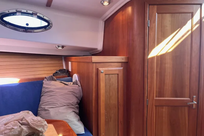 Sandpiper Yacht Photos Pics 2008 Back Cove 29 interior with wooden cabinetry and blue seating.
