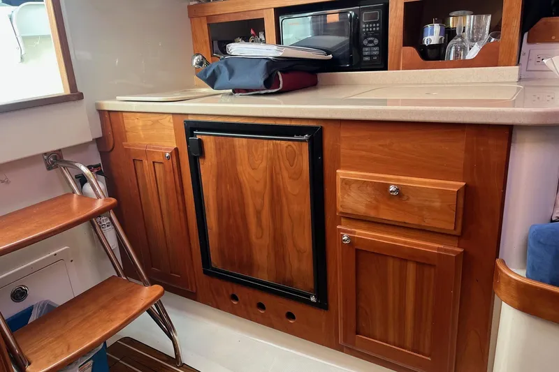 Sandpiper Yacht Photos Pics 2008 Back Cove 29 interior with wooden cabinetry, microwave, and compact kitchen setup.