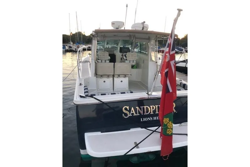 Sandpiper Yacht Photos Pics 2008 Back Cove 29 boat named "Sandpiper" docked, featuring a red flag and spacious deck.