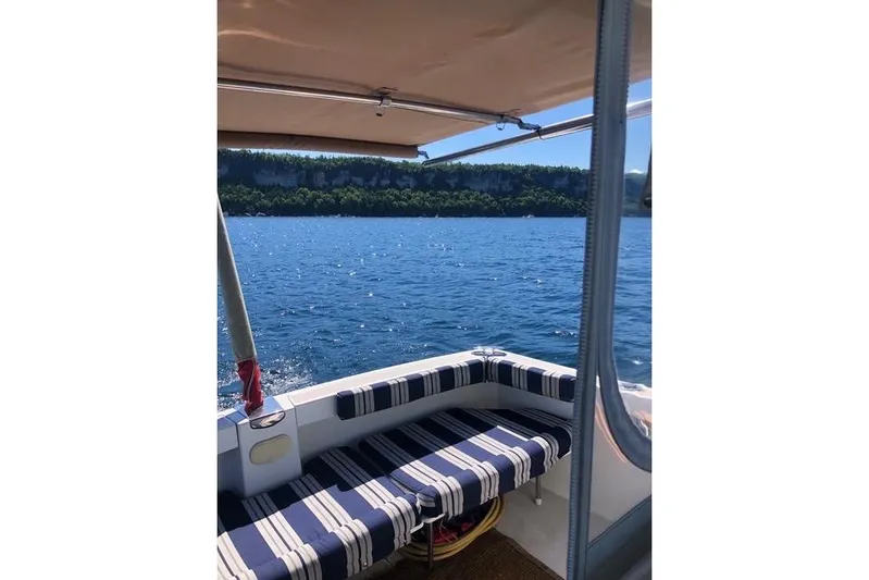 Sandpiper Yacht Photos Pics 2008 Back Cove 29 boat interior with striped seating, overlooking a scenic blue lake.
