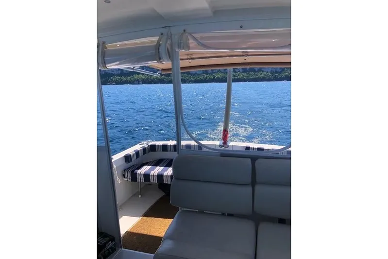 Sandpiper Yacht Photos Pics 2008 Back Cove 29 boat interior with striped seating, overlooking blue water and distant shoreline.