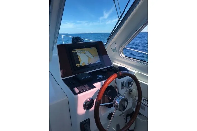 Sandpiper Yacht Photos Pics 2008 Back Cove 29 boat helm with navigation screen and wooden steering wheel.