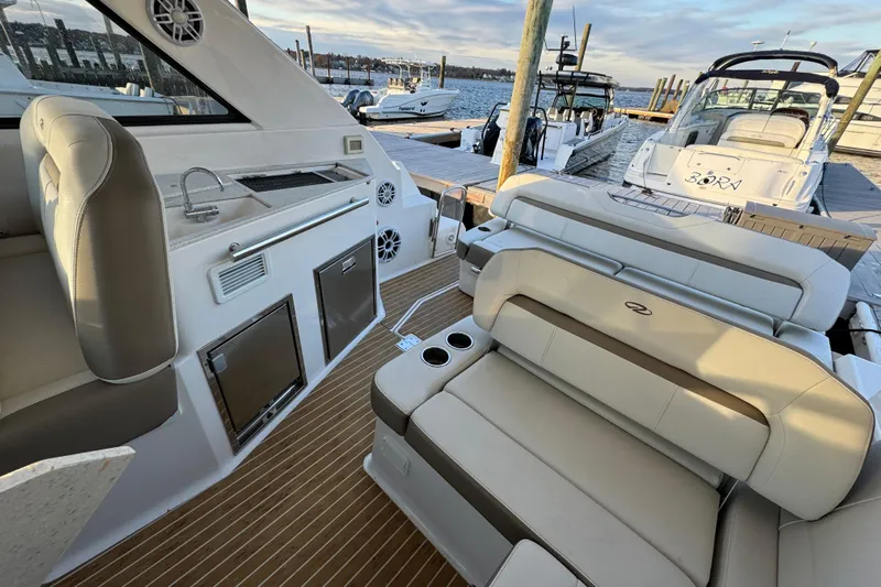  Yacht Photos Pics 2017 Regal 35 Sport Coupe interior with seating, kitchenette, and docked boats in background.