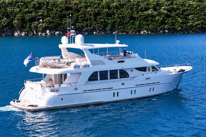 Aysha Yacht Photos Pics Luxurious 2012 Timmerman 26 yacht cruising on blue waters near a lush green coastline.