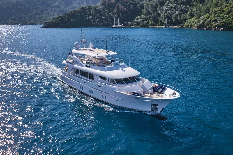 Aysha Yacht Photos Pics Luxurious 2012 Timmerman 26 yacht cruising in clear blue waters near lush green coastline.