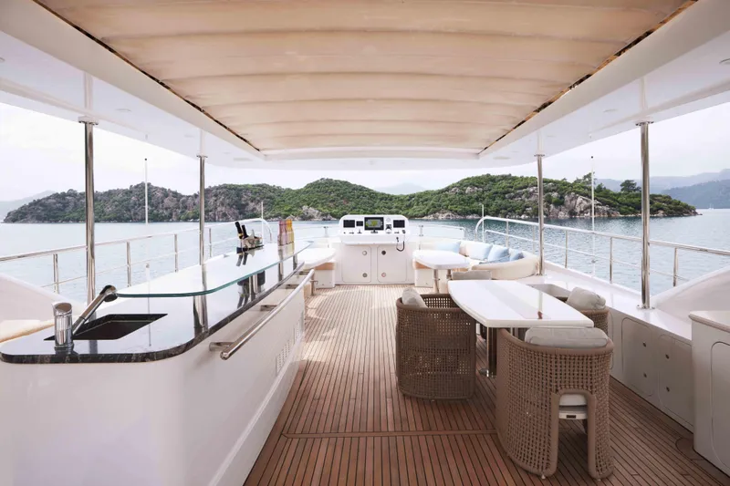 Aysha Yacht Photos Pics Luxurious Timmerman 26 yacht interior with bar and seating, overlooking serene waters and lush islands.