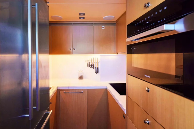 Aysha Yacht Photos Pics Modern kitchen interior on a 2012 Timmerman 26 yacht, featuring sleek appliances and wooden cabinetry.