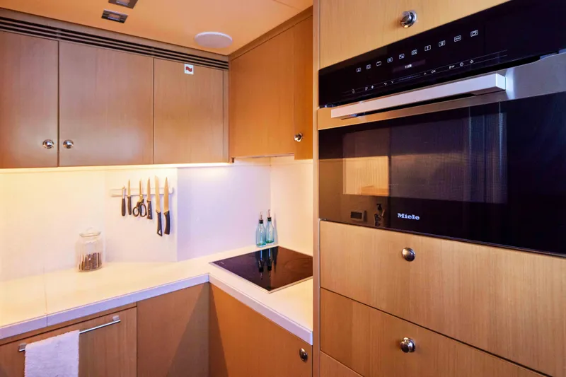Aysha Yacht Photos Pics Modern yacht kitchen with wooden cabinets, Miele oven, and knife set. Timmerman 26, 2012 model.