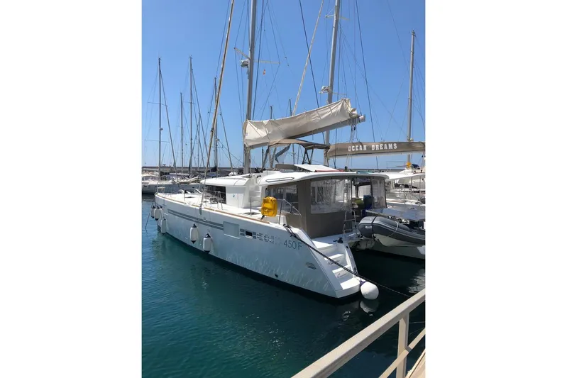 Honu Yacht Photos Pics 2015 Lagoon 450 F catamaran docked in a marina under clear blue skies.