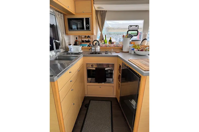 Honu Yacht Photos Pics Modern kitchen interior of 2015 Lagoon 450 F catamaran, featuring appliances and ample counter space.