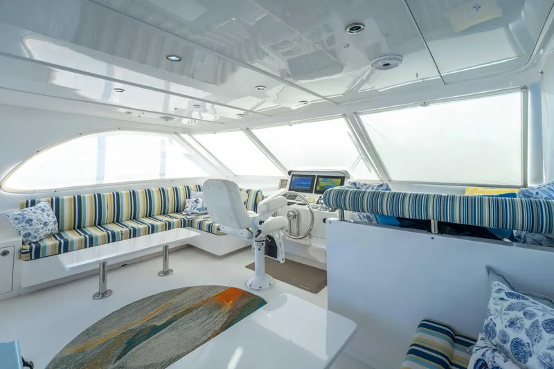 Sea Dreamz Yacht Photos Pics Luxurious interior of 2016 Horizon PC52 yacht with striped seating and modern helm.
