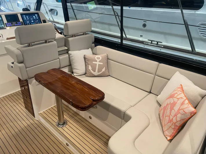 Artemis Yacht Photos Pics Luxurious interior of 2023 MJM 4 boat with plush seating and elegant wooden table.