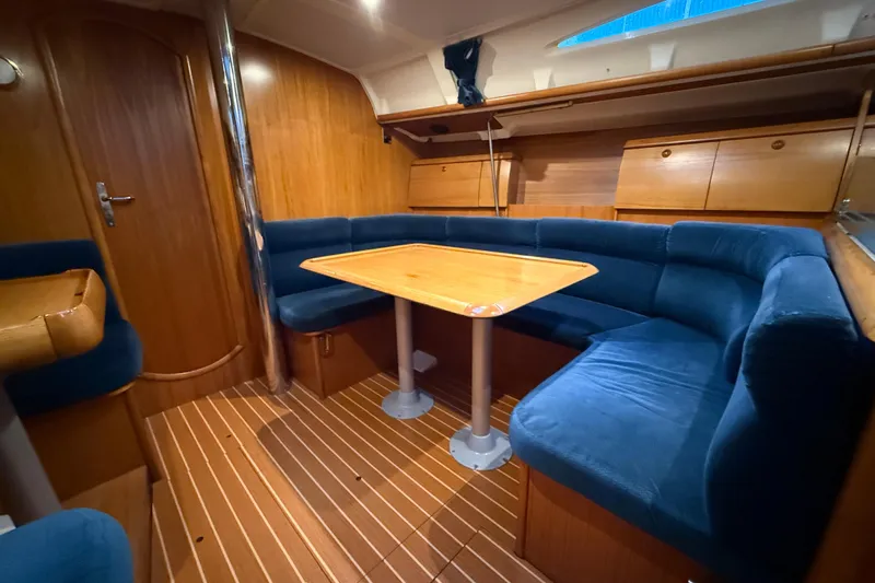 Summer Solace Yacht Photos Pics Interior of 2000 Jeanneau Sun Odyssey 40 sailboat with wooden finish and blue seating.
