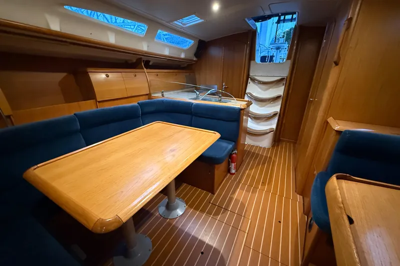 Summer Solace Yacht Photos Pics Interior of 2000 Jeanneau Sun Odyssey 40 sailboat with wooden furnishings and blue seating.