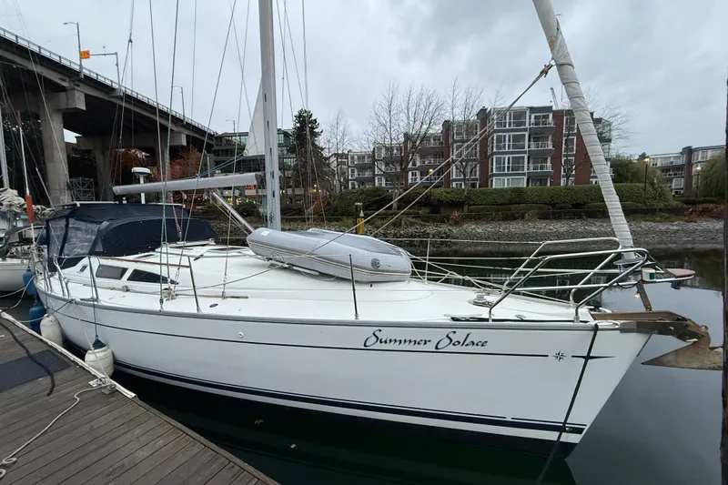 Summer Solace Yacht Photos Pics 2000 Jeanneau Sun Odyssey 40 sailboat docked near modern apartments.