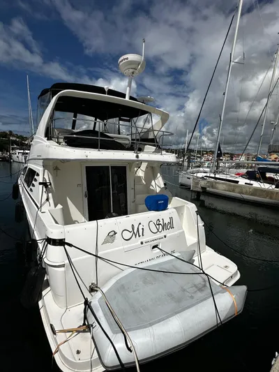  Yacht Photos Pics 2006 Silverton 43 Sport Bridge yacht docked at marina under cloudy sky.