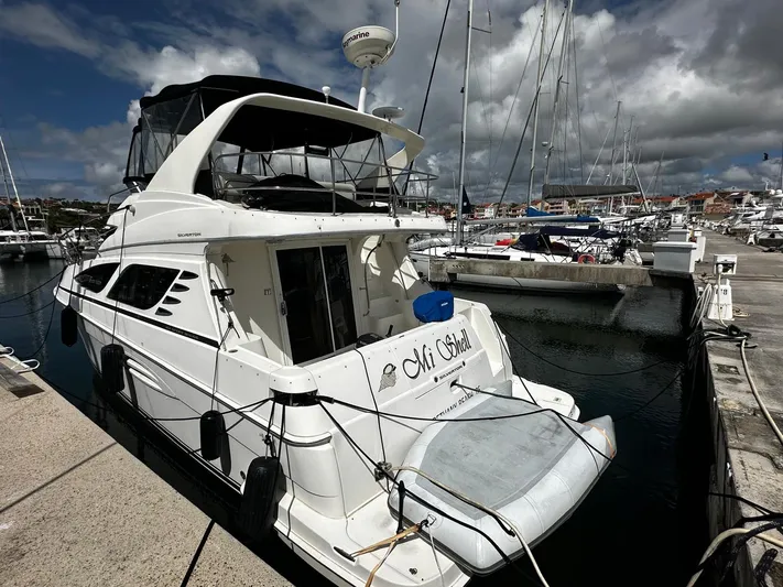 Yacht Photos Pics 2006 Silverton 43 Sport Bridge yacht docked at a marina under cloudy skies.